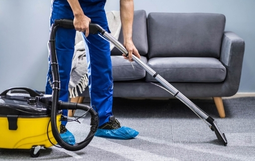 Man cleaning floor with vacuum cleaner, demonstrating cleaning equipment available at Starlinks